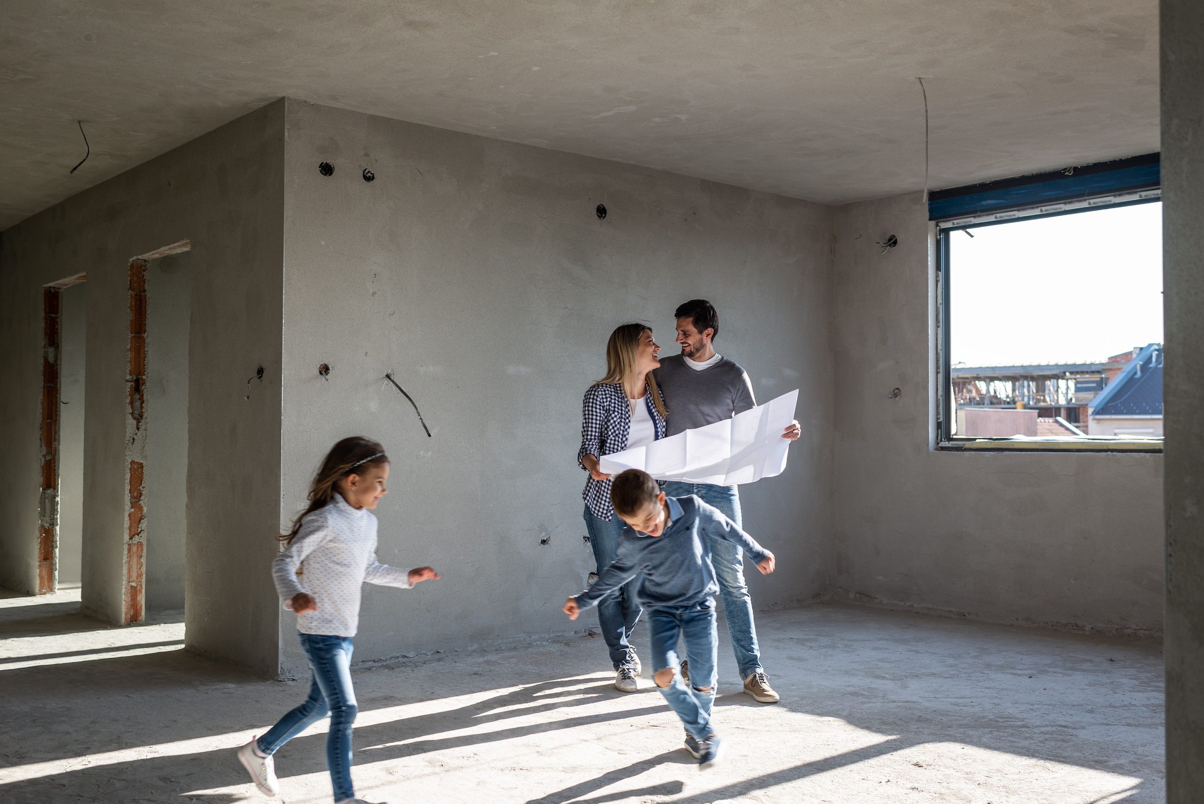 Happy family analyzing plans at their new apartment INNENAUSBAU