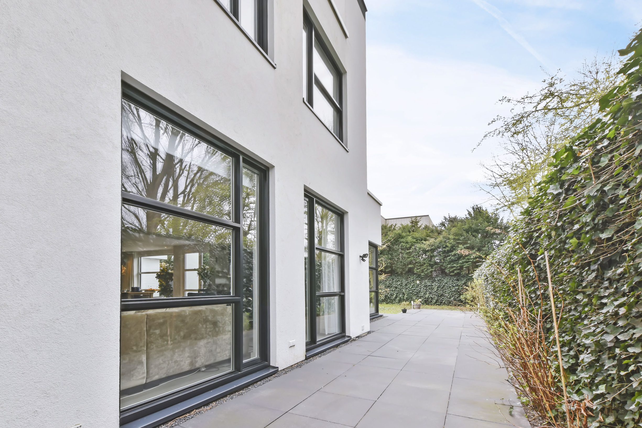 The courtyard of the house is in a minimalist style with large windows SCHLÜSSELFERTIGBAU